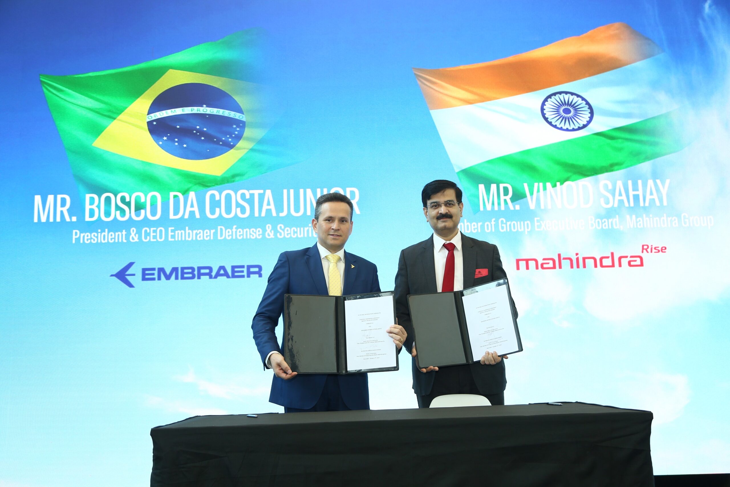 Embraer and Mahindra executives signing SCA for C-390 in New Delhi